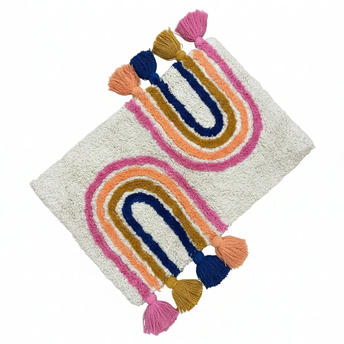 Overhead view of a cream bath mat with colourful arches and tassels