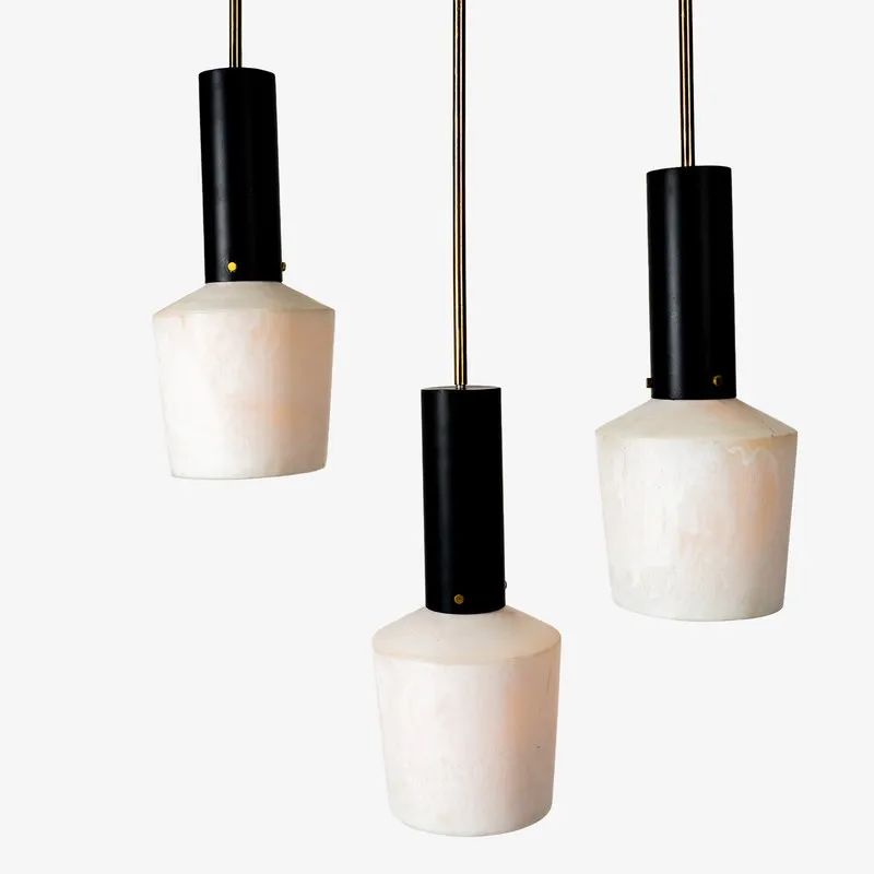 Three hanging pendant lights with black stems and off-white shades