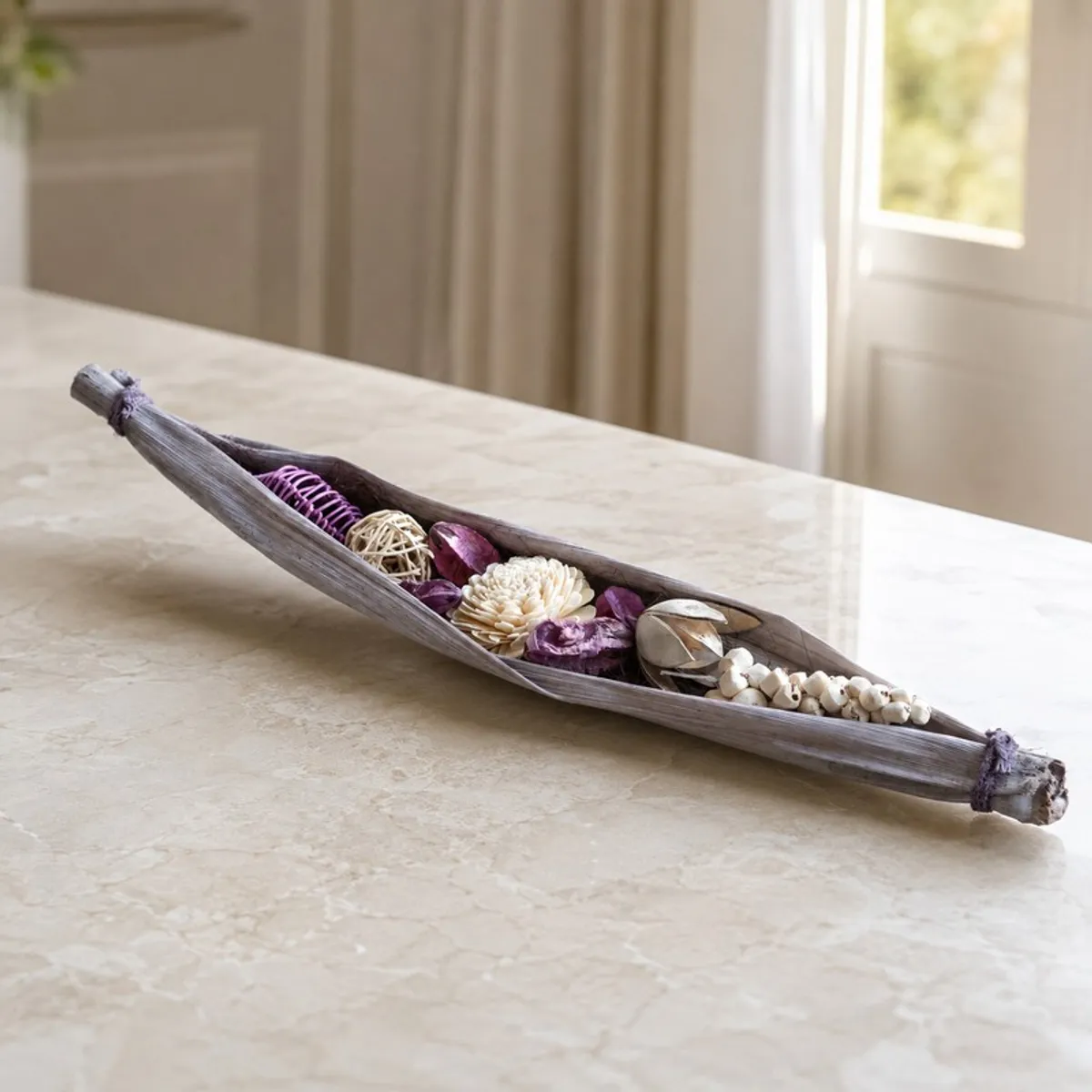 Long artificial flower arrangement placed across a light marble surface.