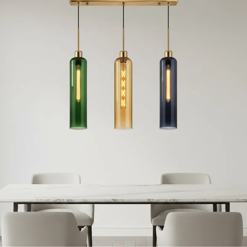 Three hanging tubular glass pendant lights on a gold bar above a dining table