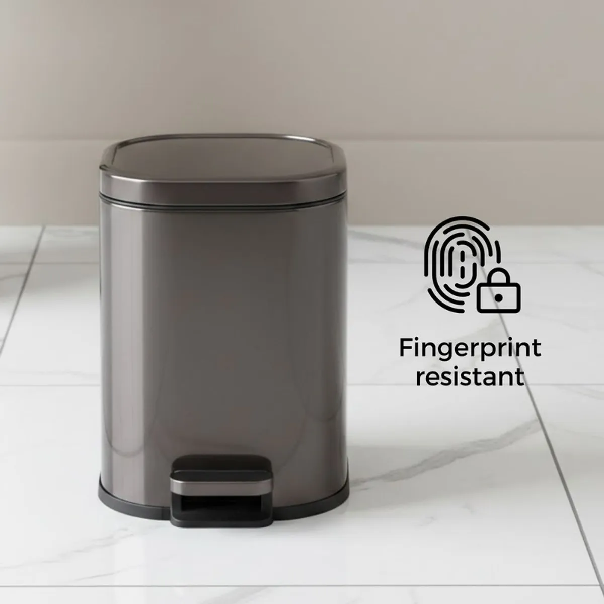 Closed black and silver metal dustbin on a light floor