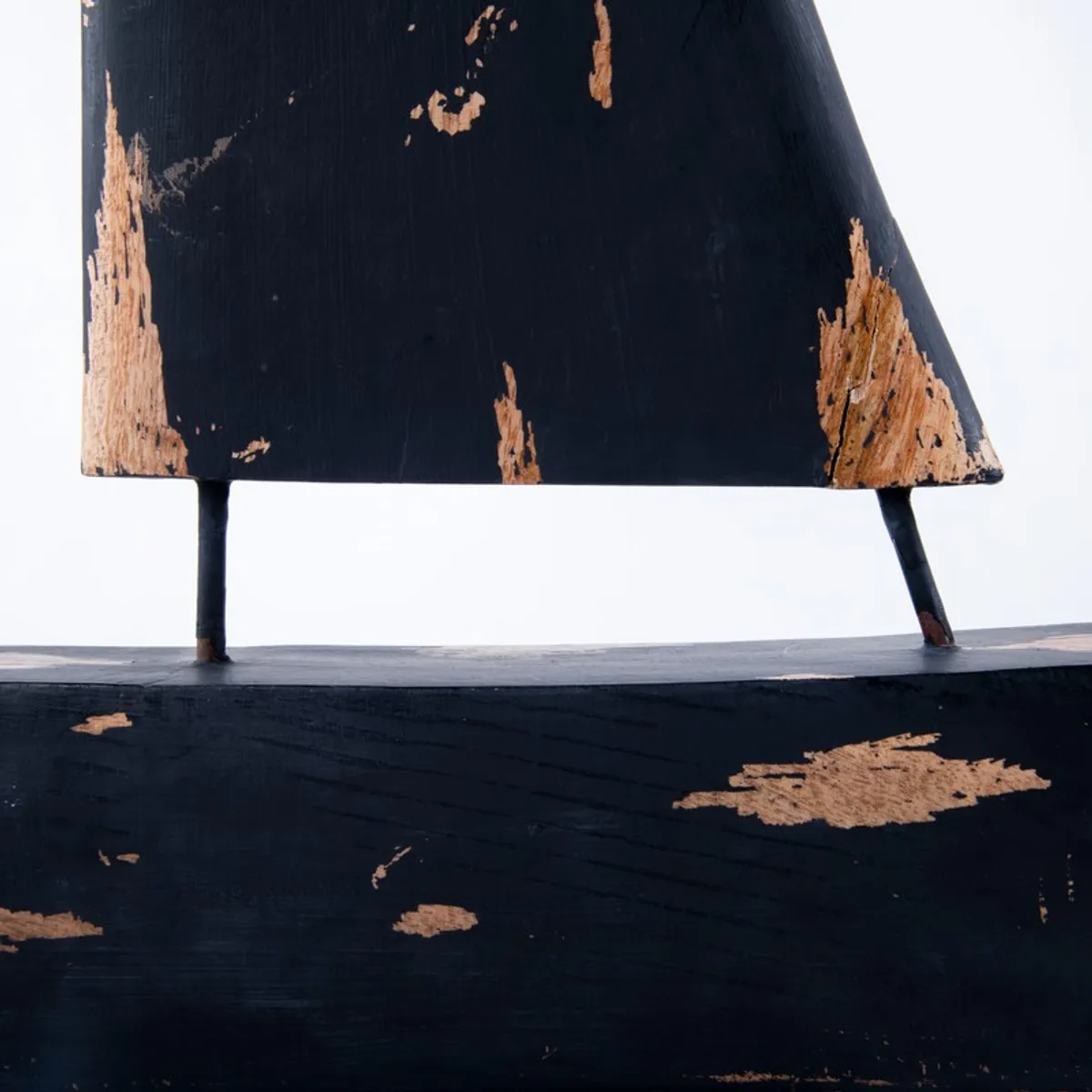 Close-up view of the showpiece's distressed black sail and boat body