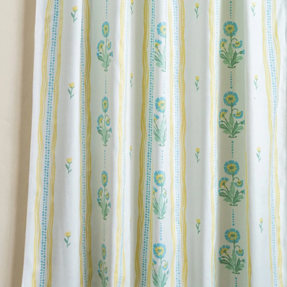 Blue and yellow floral striped curtains shown hanging in soft light