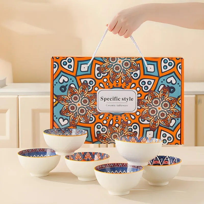 Six patterned ceramic bowls displayed in front of a decorative orange presentation box.