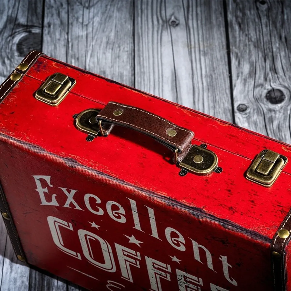 Close-up of the red box showing its dark handle, metal latches and distressed typography finish