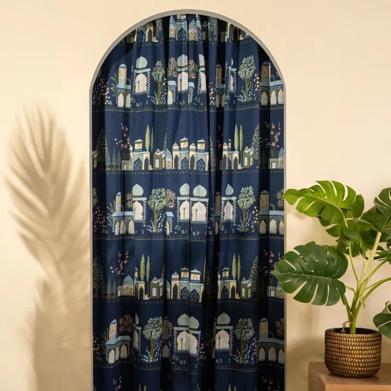 Blue patterned curtain fitted inside an arched doorway.