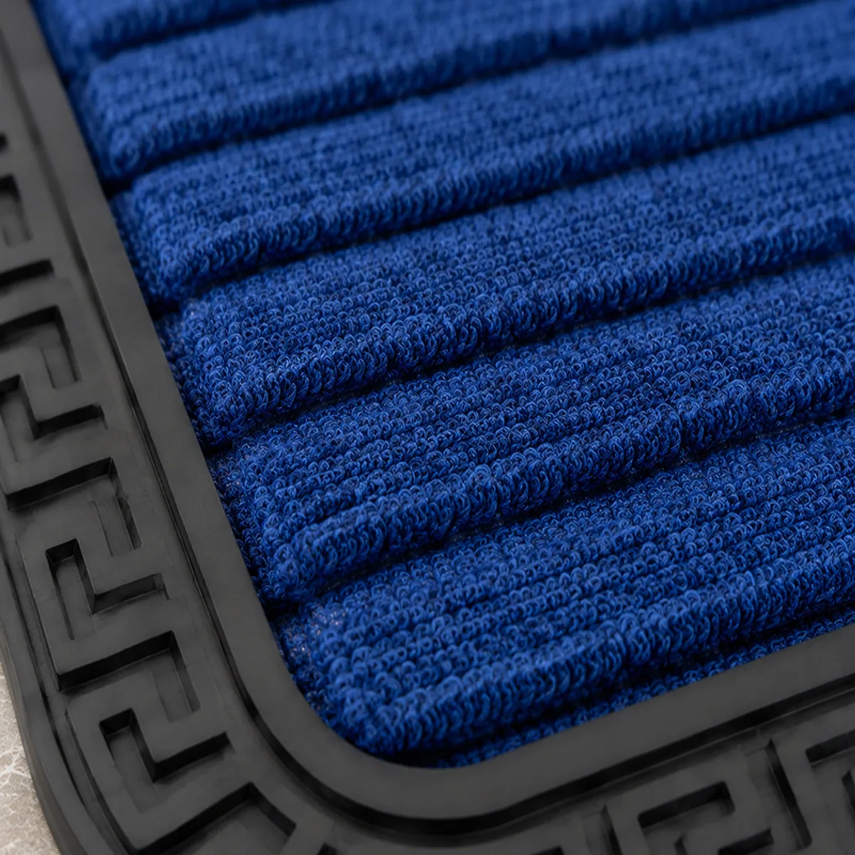 Close-up of blue textured mat surface and black patterned rubber border