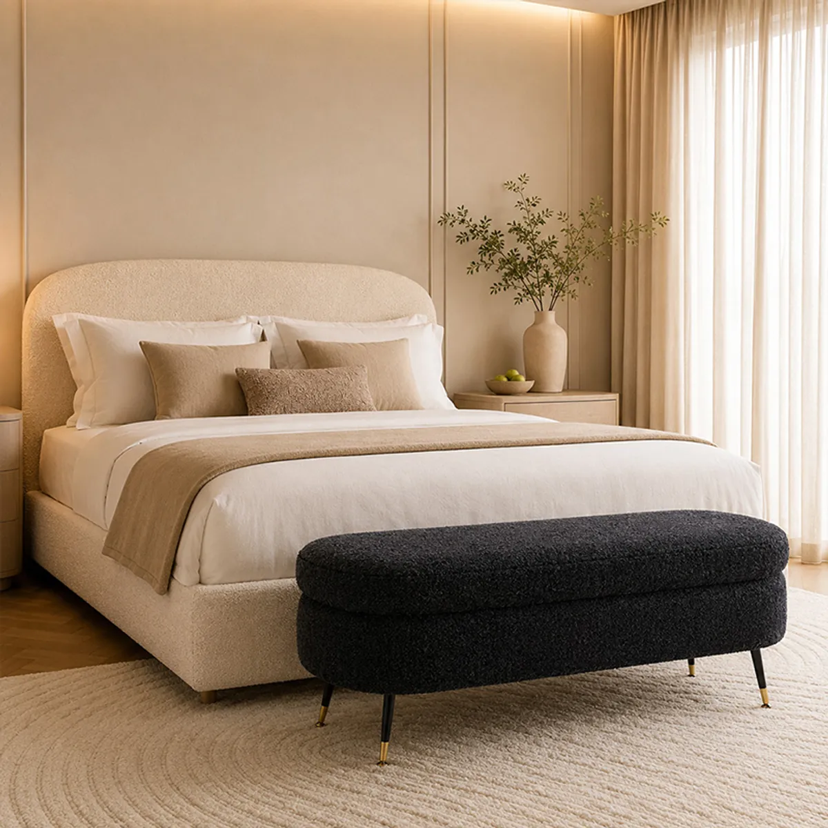 Dark grey upholstered bench placed on a patterned rug in a bright room