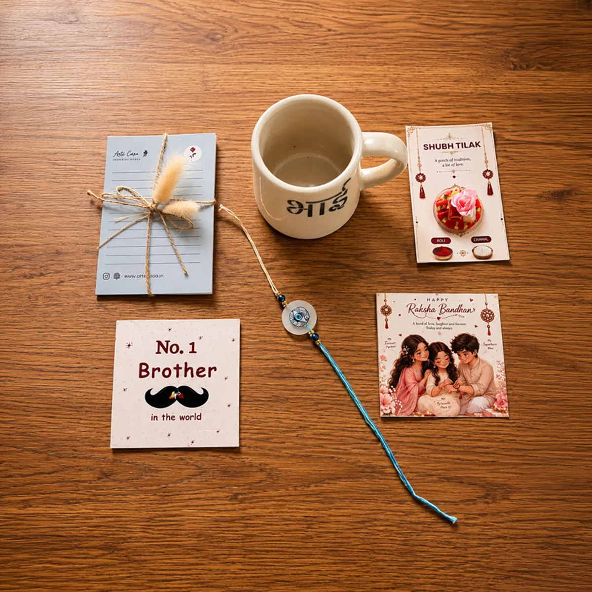 Rakhi, ceramic mug and Raksha Bandhan cards arranged on a wooden surface