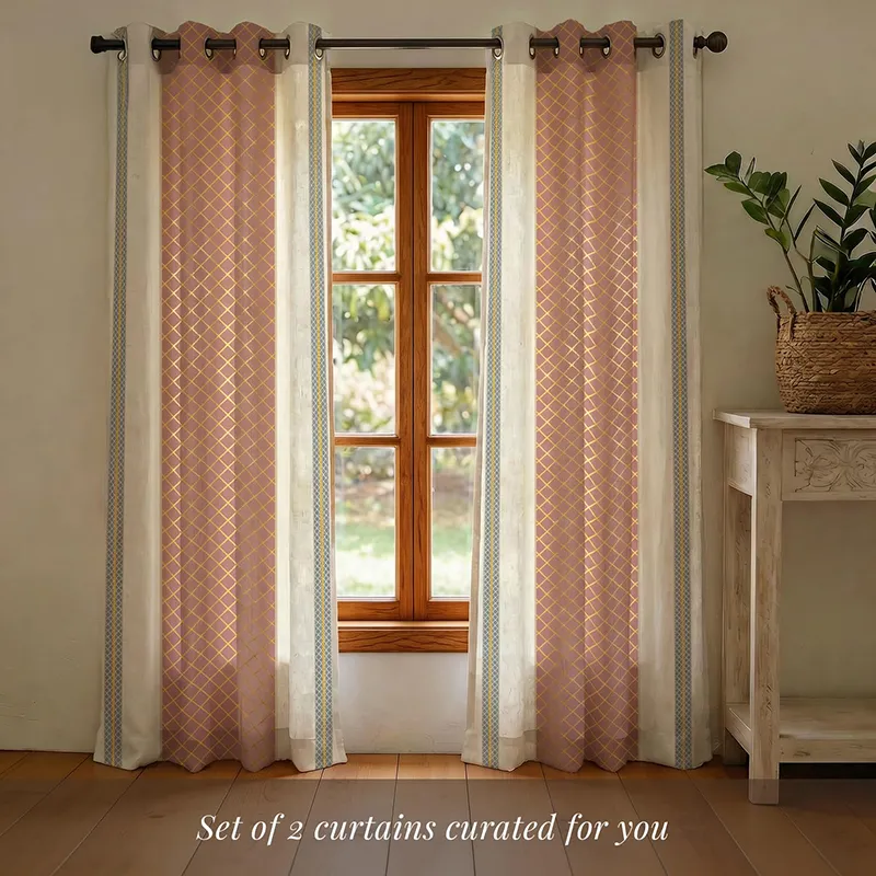 Set of pink, gold and off-white eyelet curtains hanging on a window