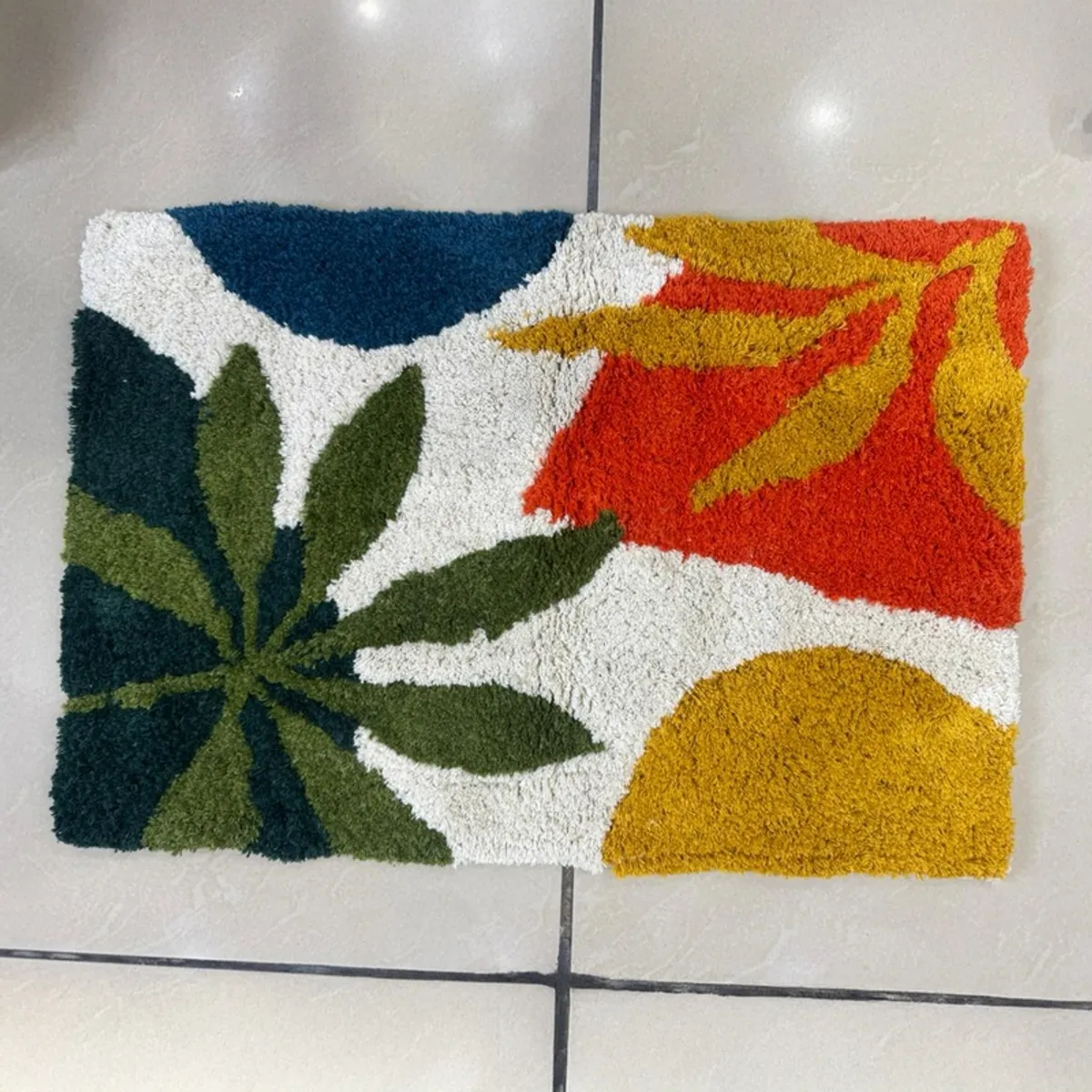 Top view of the rectangular bath mat on a tiled floor.
