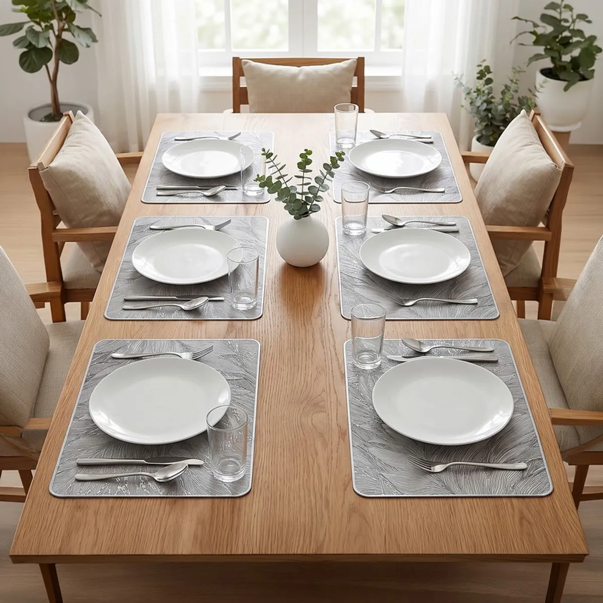 Six grey patterned table mats arranged on a wooden dining table
