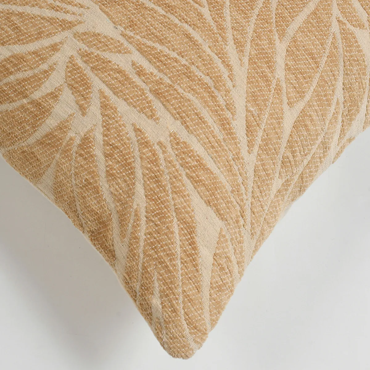 Close-up of the beige textured leaf-patterned cotton cushion cover