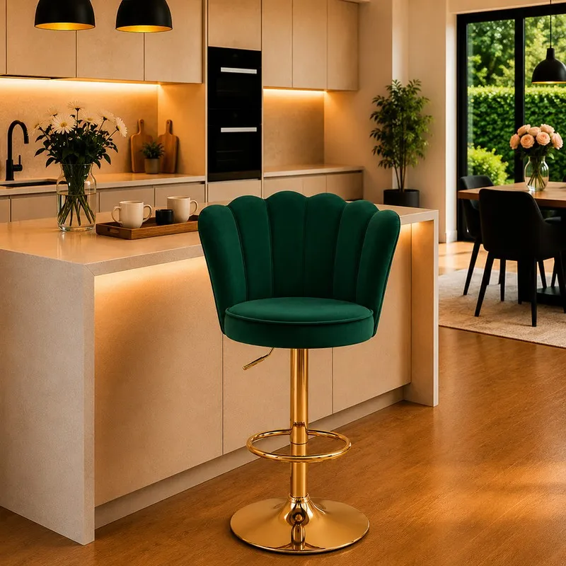 Green velvet bar chair with scalloped back and gold-toned metal base in a modern kitchen