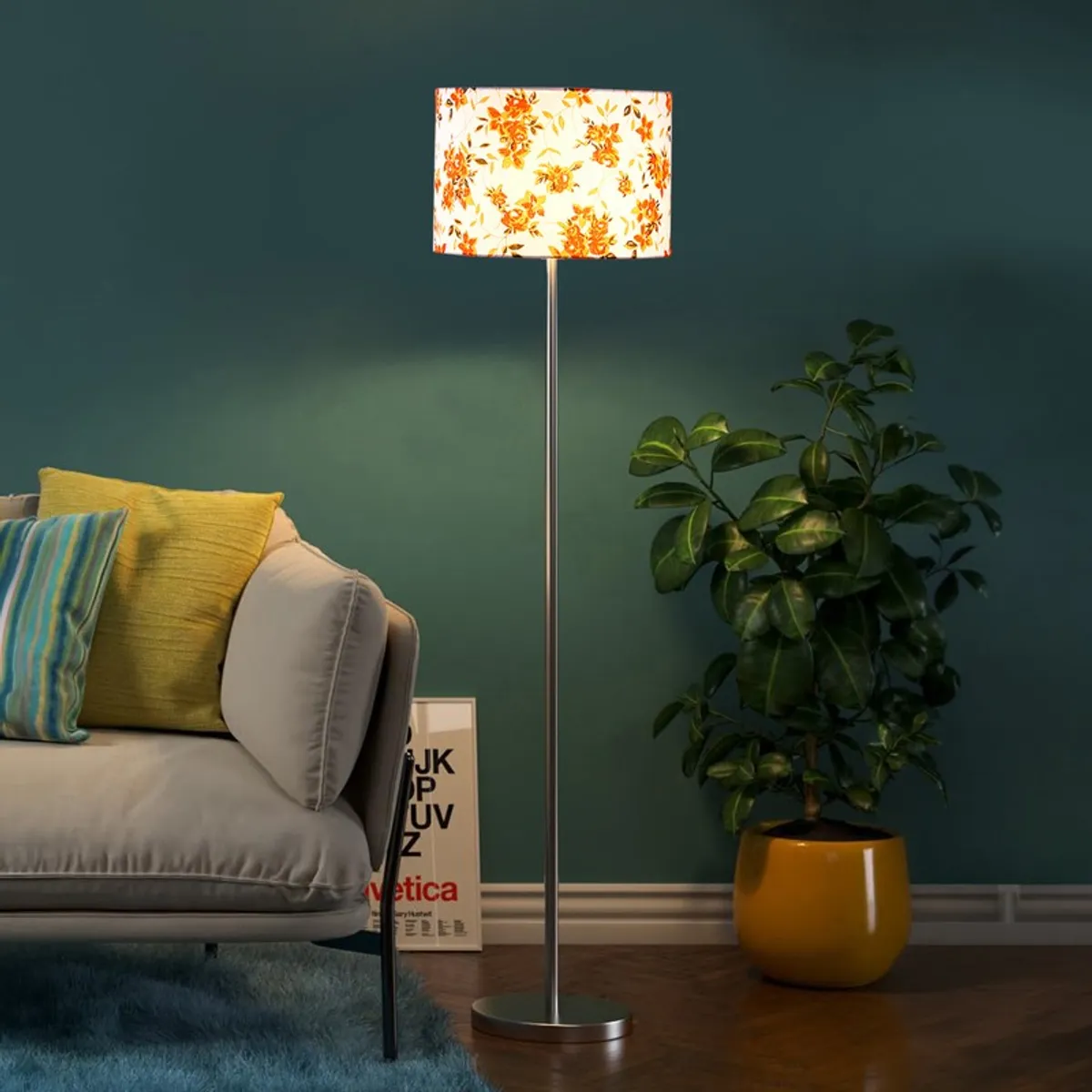 Lit floral shade floor lamp near a sofa and potted plant against a dark teal wall