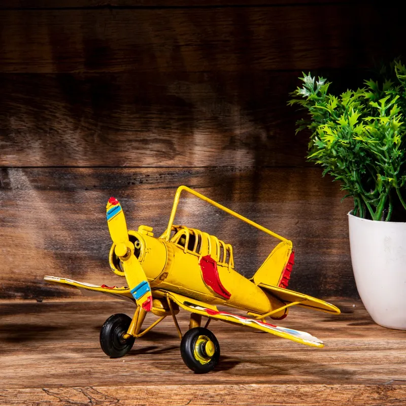 Yellow vintage airplane showpiece displayed on a wooden surface
