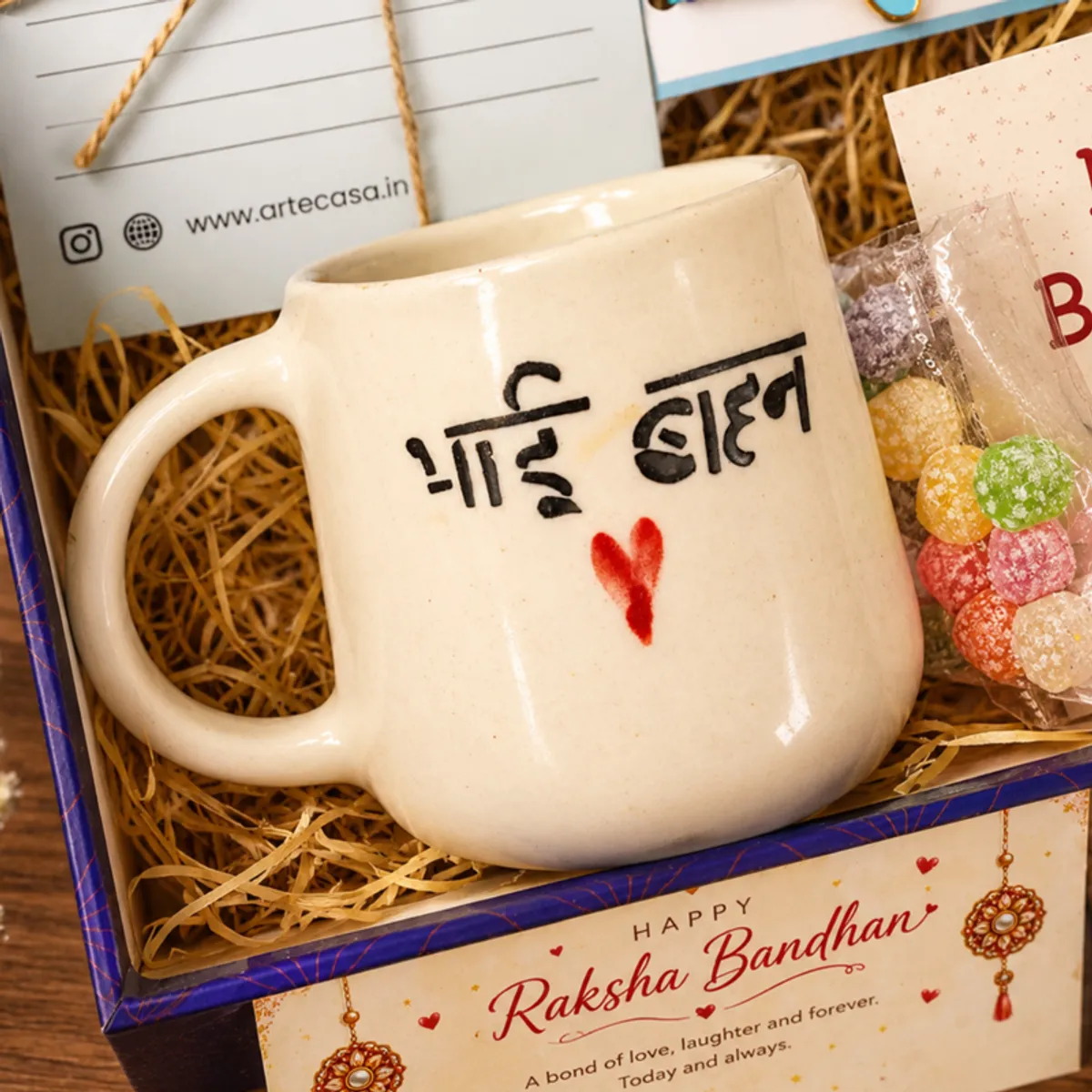 Close-up of the Bhai Behan mug inside the blue gift box with festive cards and sweets.