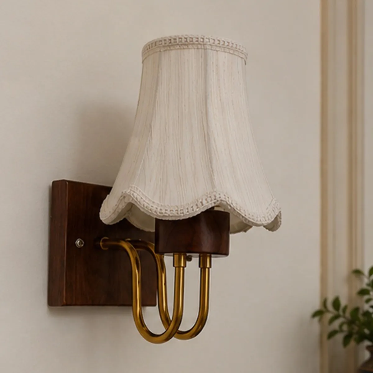 Front view of a white cotton wall lamp with brown wood and gold metal details