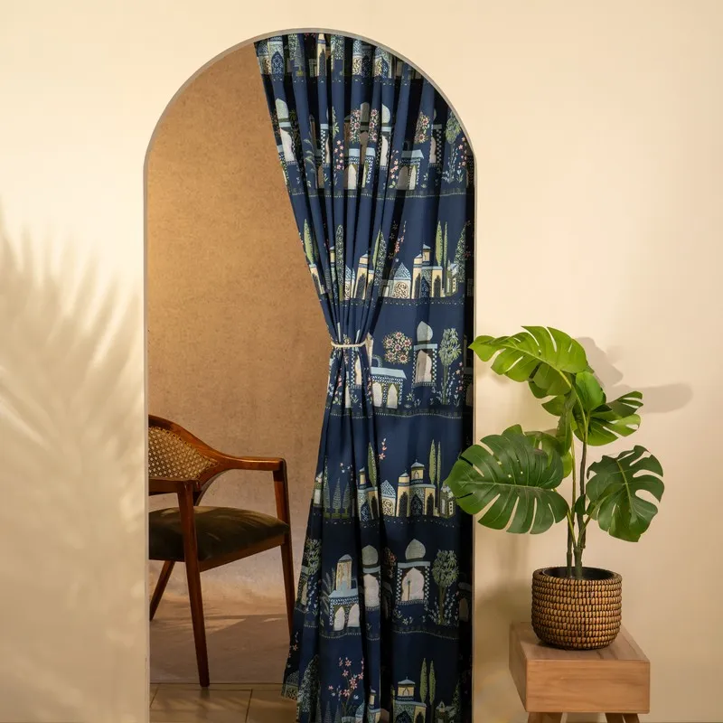 Arched doorway dressed with a blue curtain tied to one side.