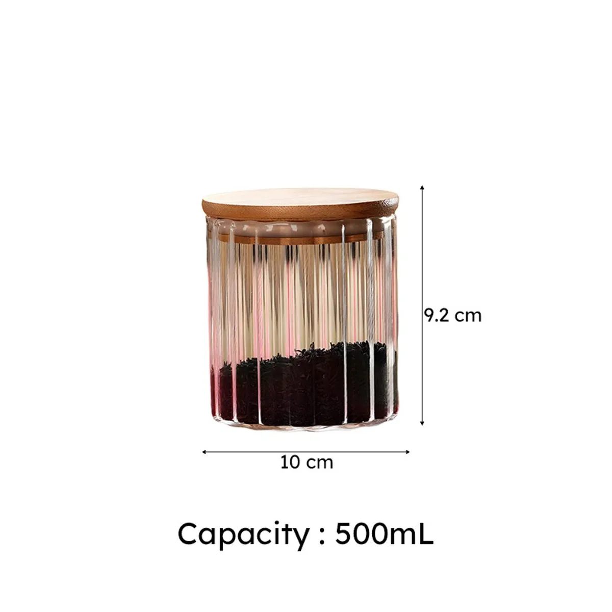 Close view of the clear fluted glass jar and bamboo lid filled with coffee beans.