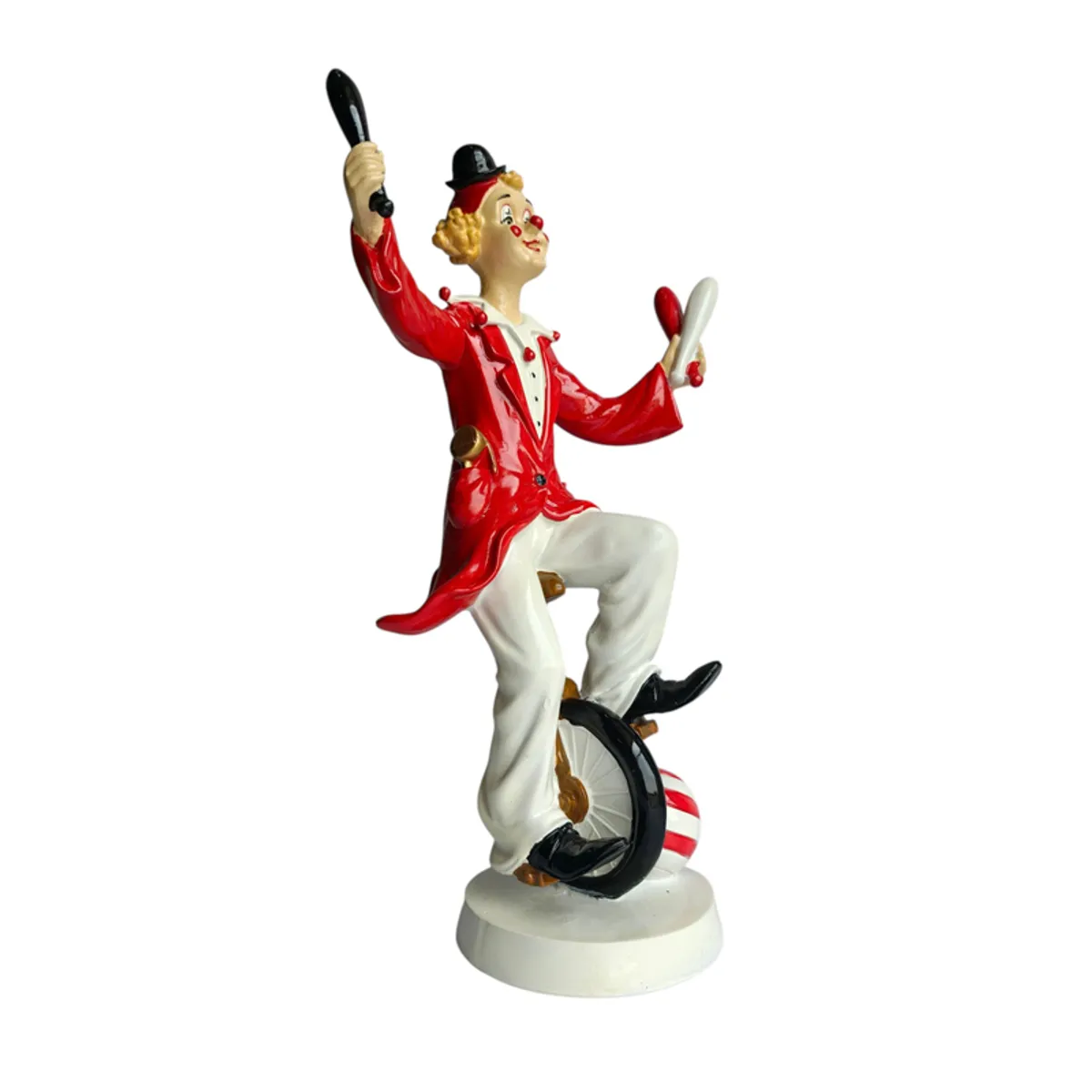 Side view of the clown figurine in a red costume on a unicycle
