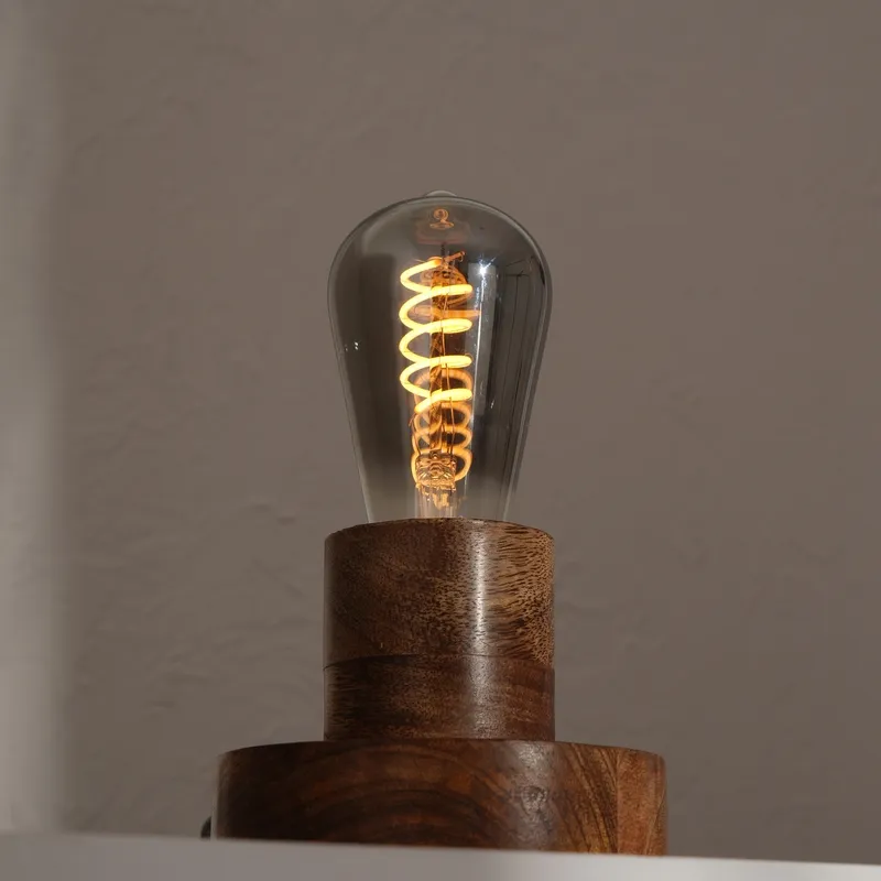 Close-up of smoked glass bulb on a brown wooden table lamp base