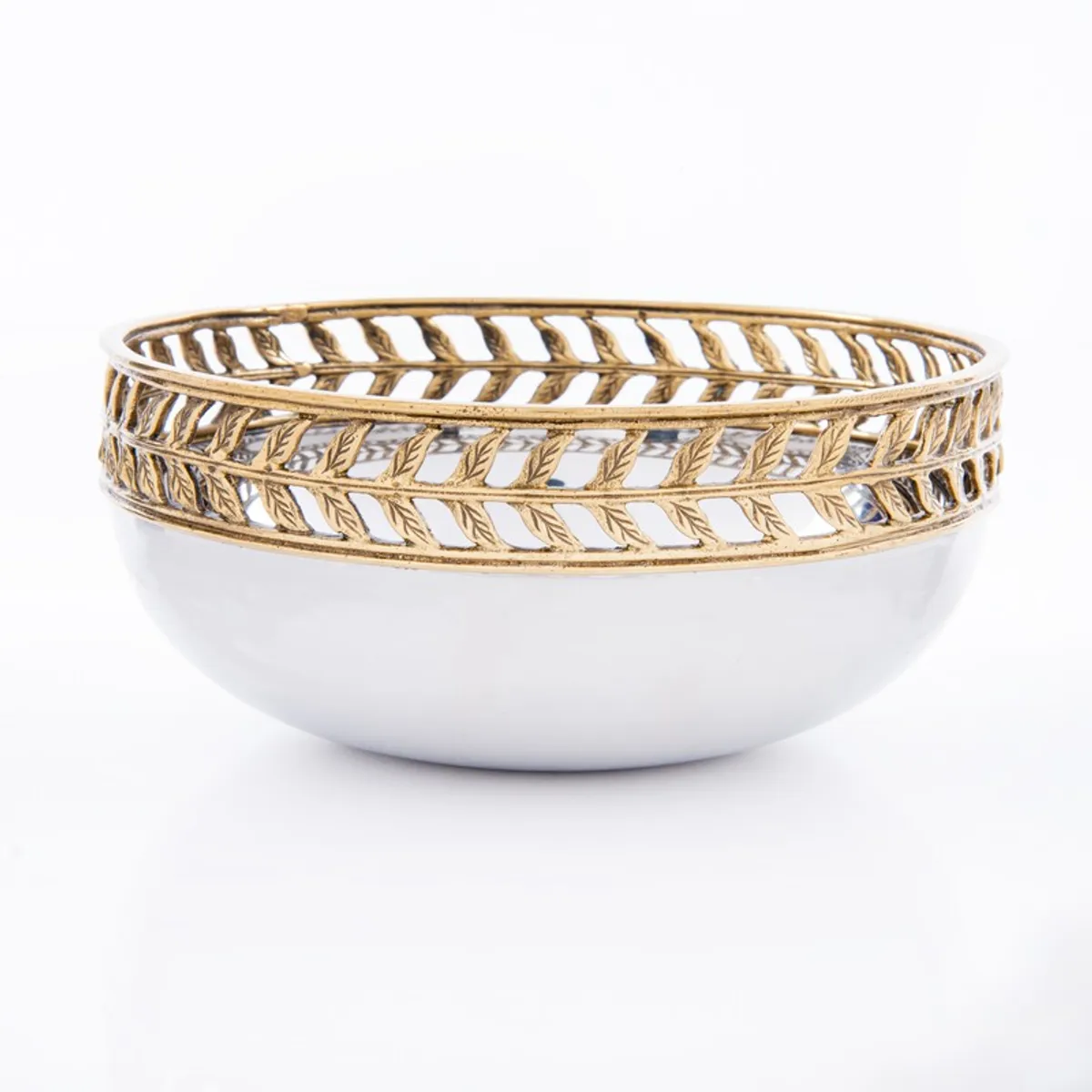 Side view of a glossy silver bowl with a gold openwork leaf-pattern rim