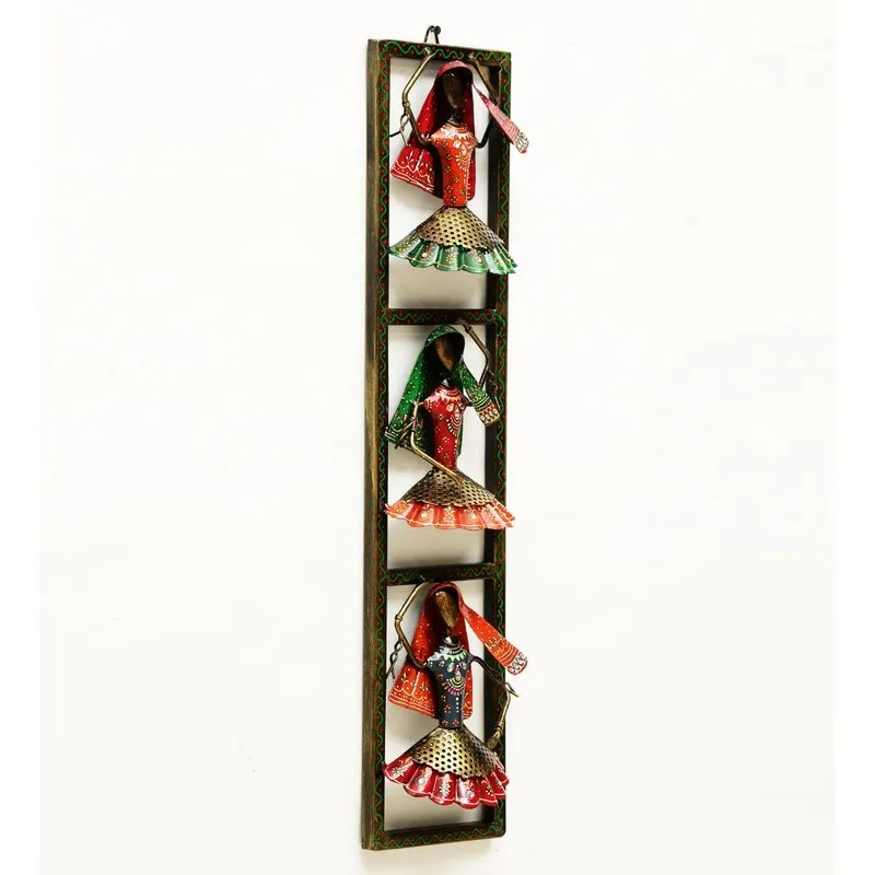 Angled view of narrow rectangular metal wall accent with three painted figures