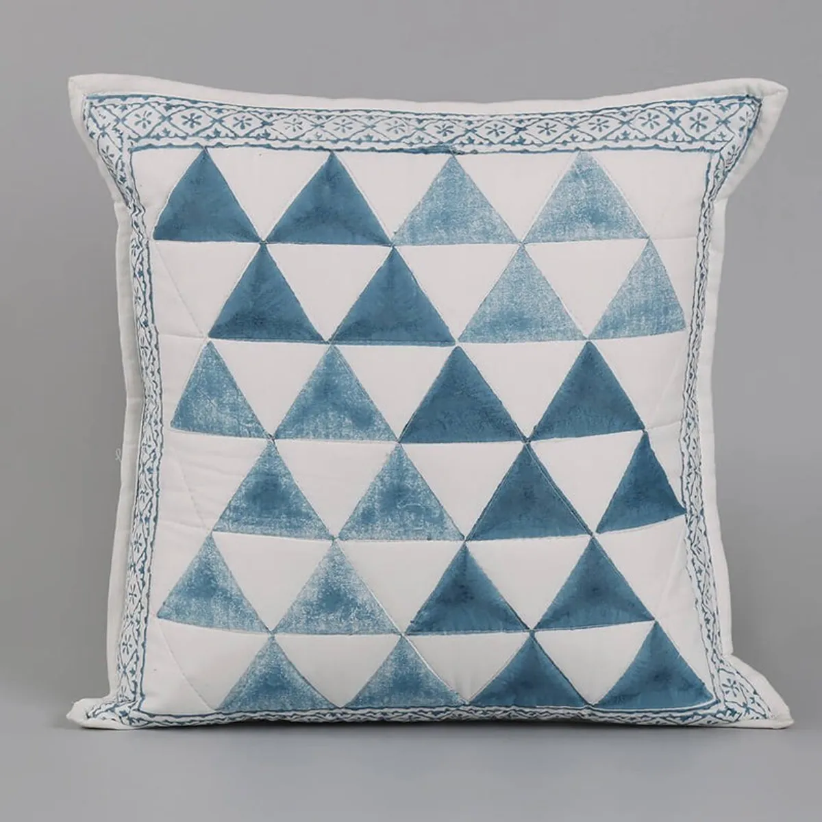 Close-up of a blue and white geometric tufted cushion cover