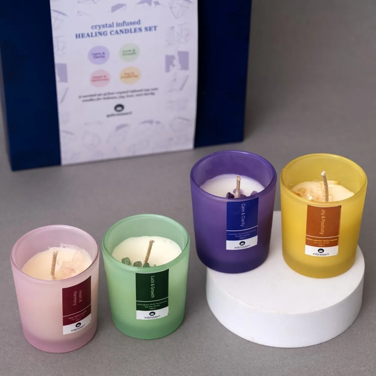 Four coloured glass candles displayed with visible soy wax and decorative contents