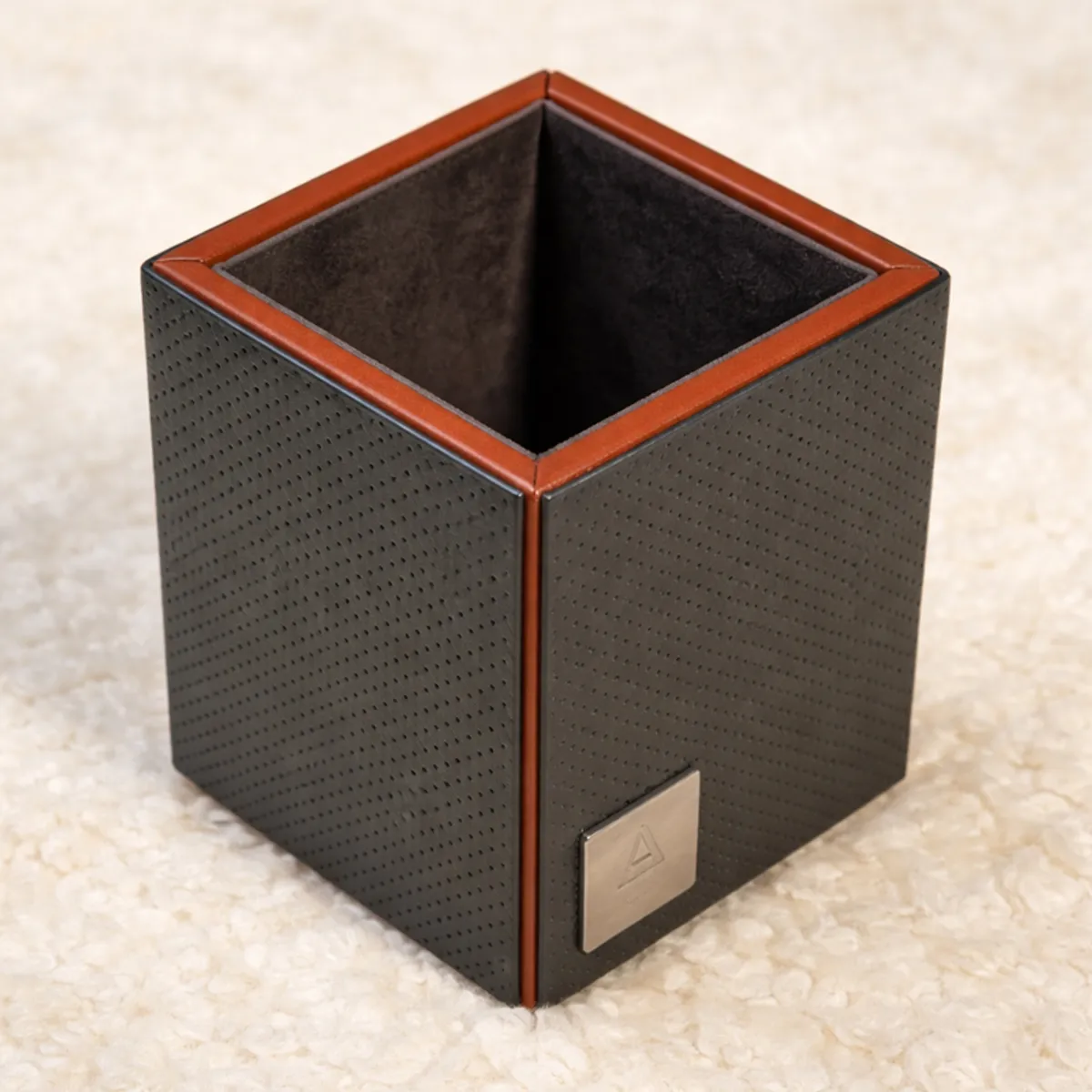 Close view of an empty square grey and brown pen stand