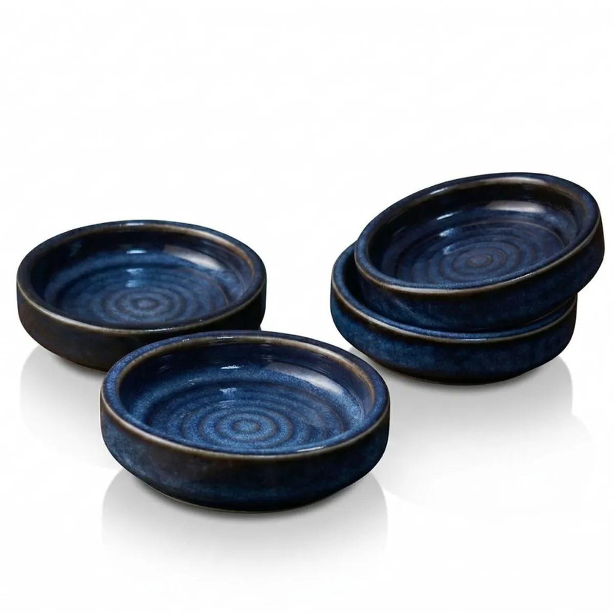 Set of four round blue ceramic dip bowls on a white background