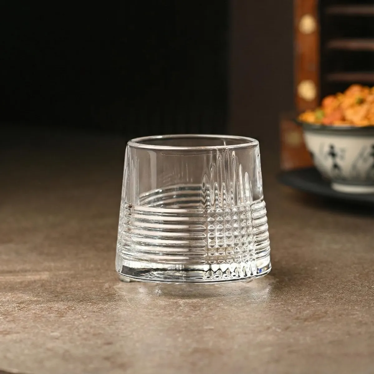 Empty clear textured whiskey glass on a tabletop