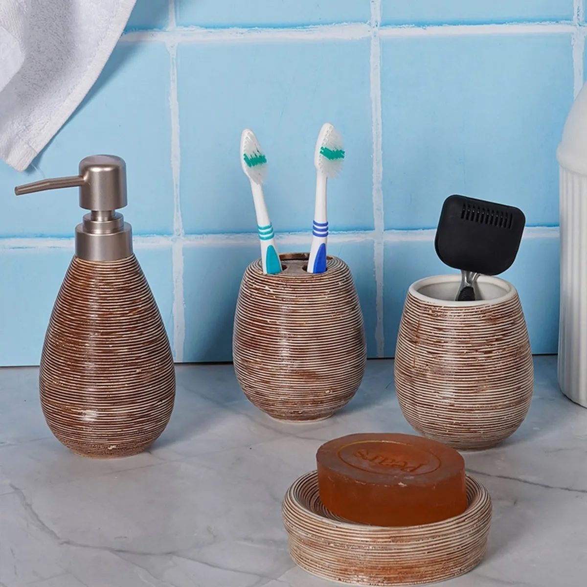 Brown ceramic bathroom accessories shown with toothbrushes, soap and a dispenser