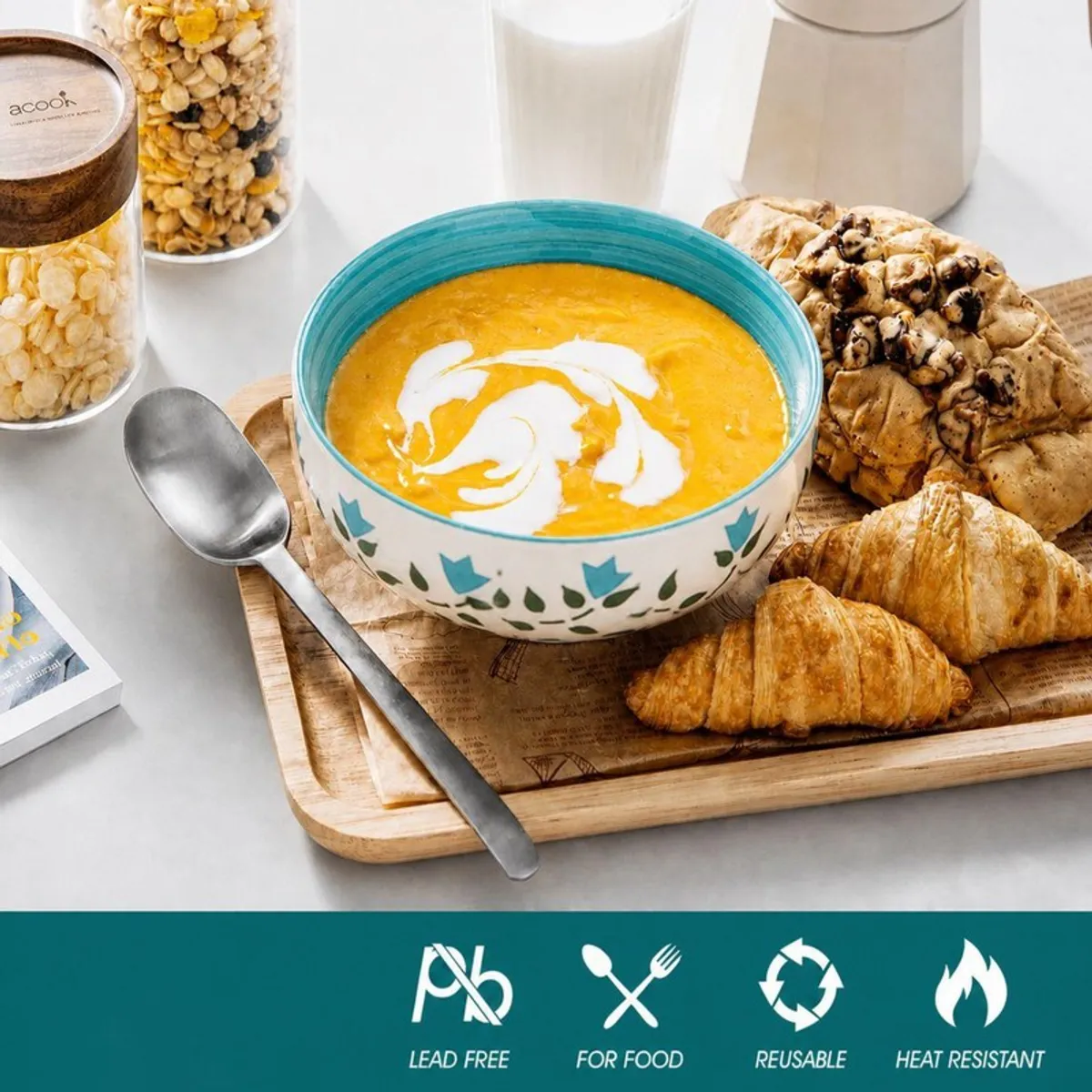 Ceramic bowl filled with soup alongside bread and a spoon