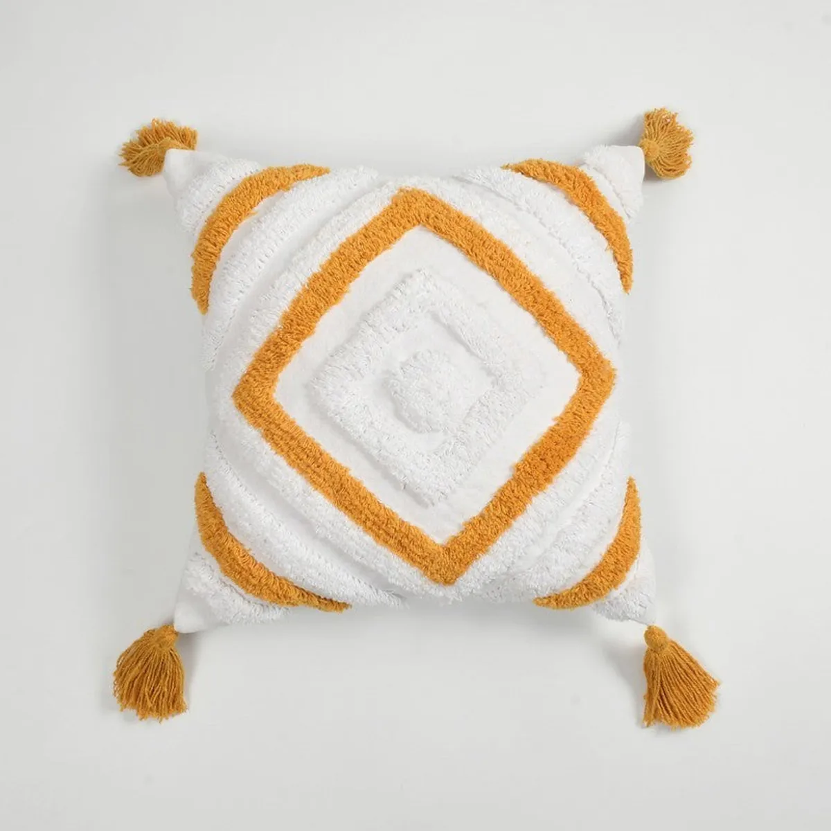 Front view of square white cushion cover with yellow geometric tufting and four tassels