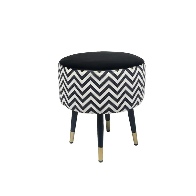Angled view of the chevron ottoman with black and gold-tipped legs