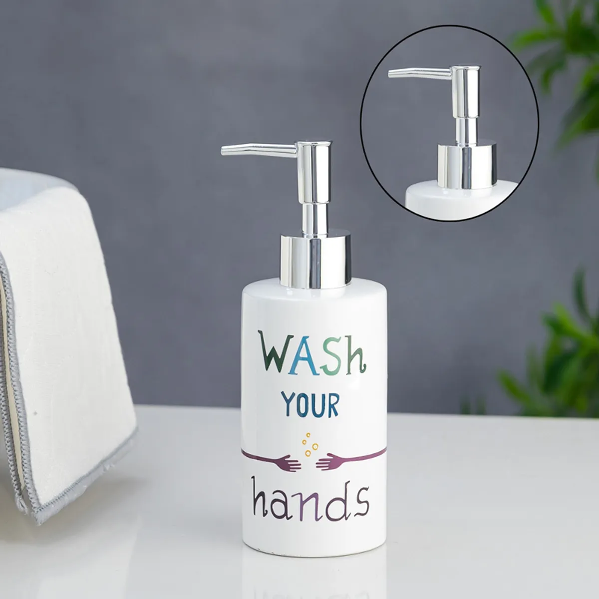 White typographic soap dispenser with silver pump and close-up pump detail