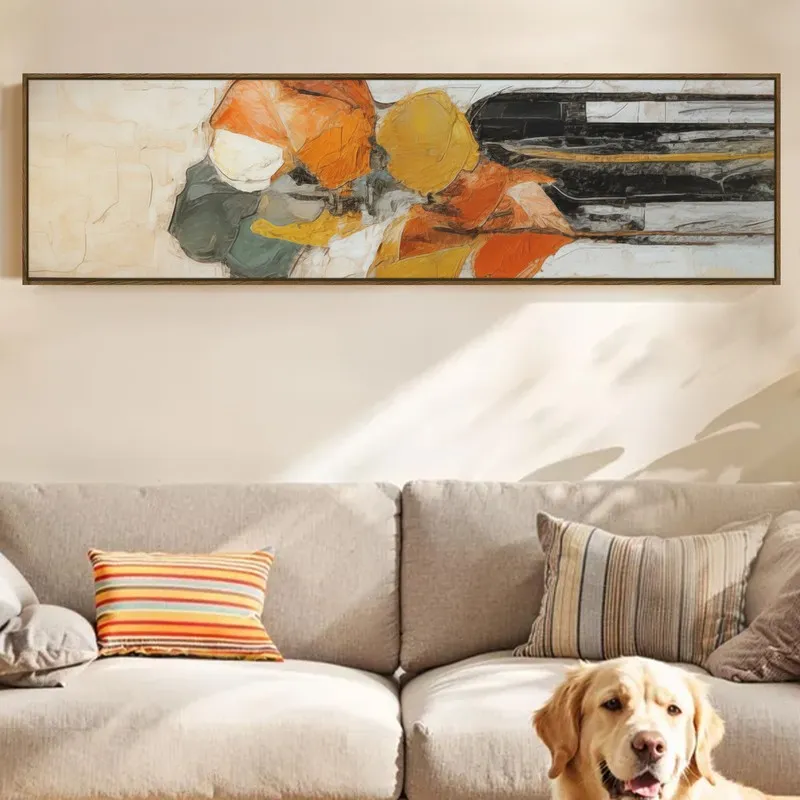 Wide framed abstract canvas art with orange, yellow and black accents above a sofa