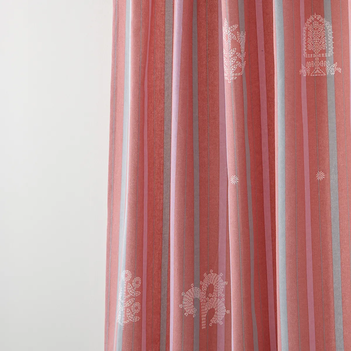 Close-up of pink striped curtain fabric with white decorative motifs