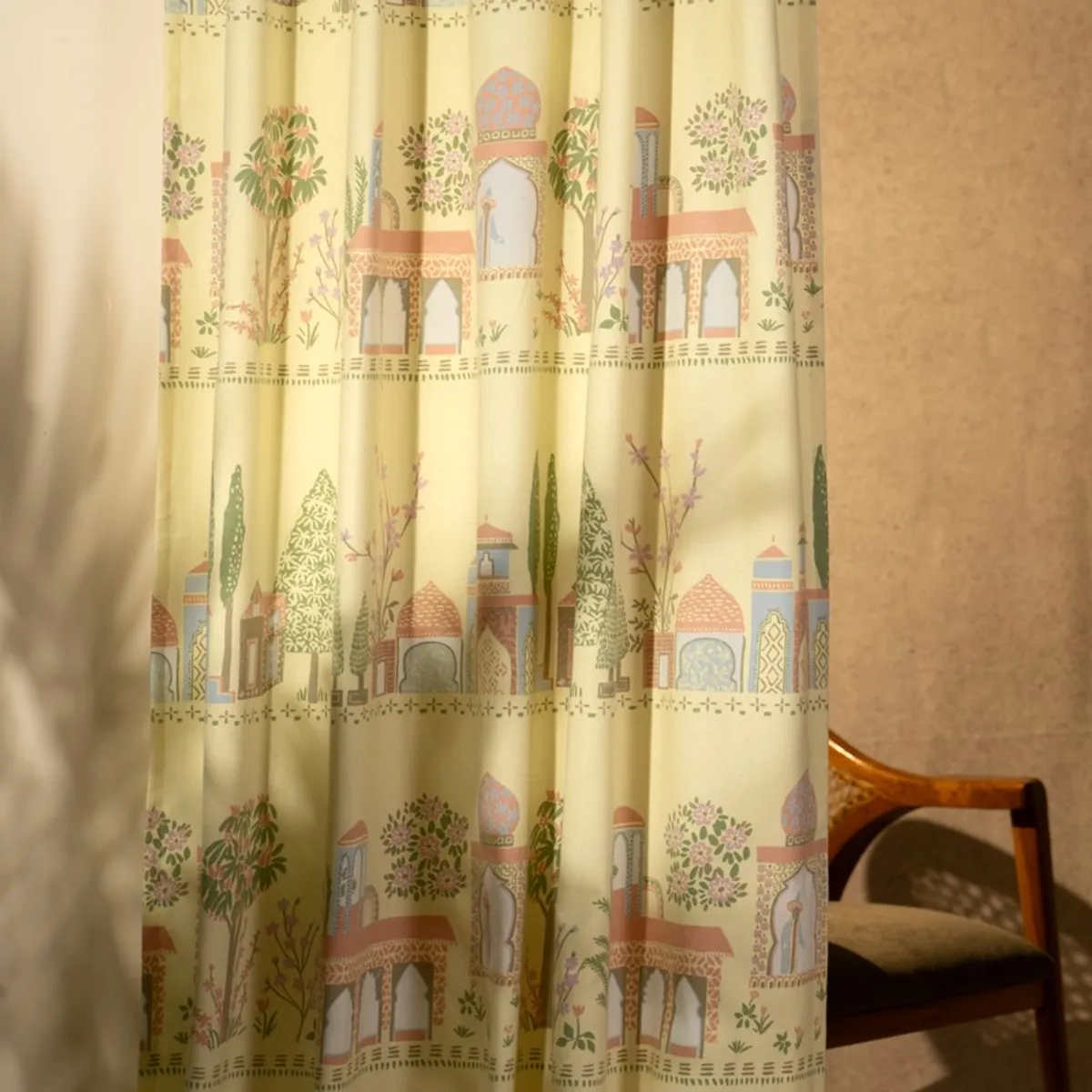 Close-up view of colourful palace and floral motifs on yellow curtain fabric