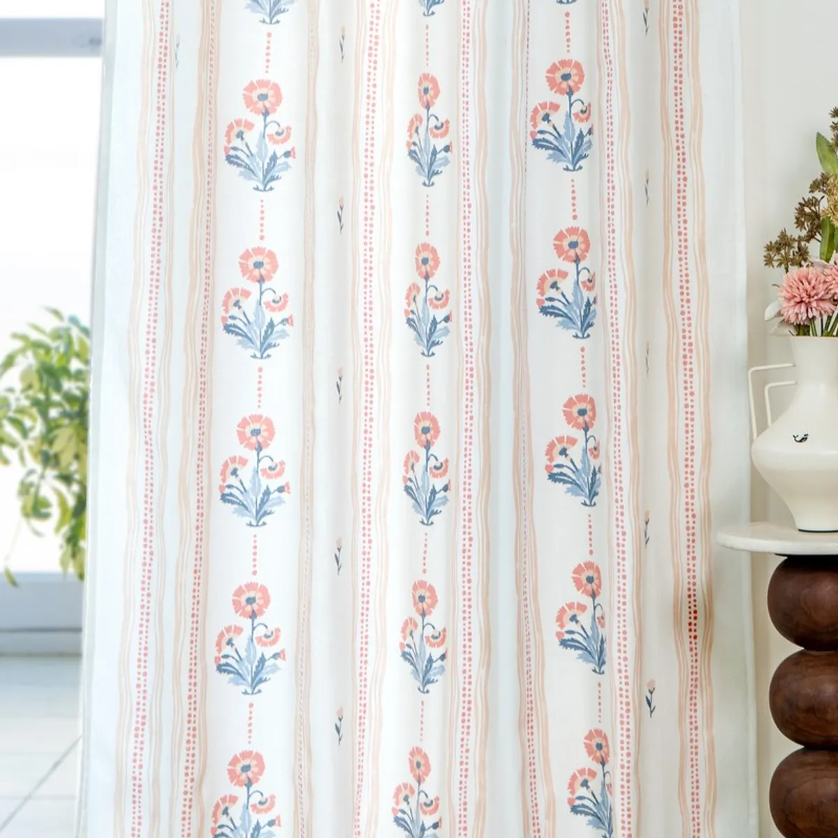 Close view of floral curtain panels with repeating vertical botanical stripes