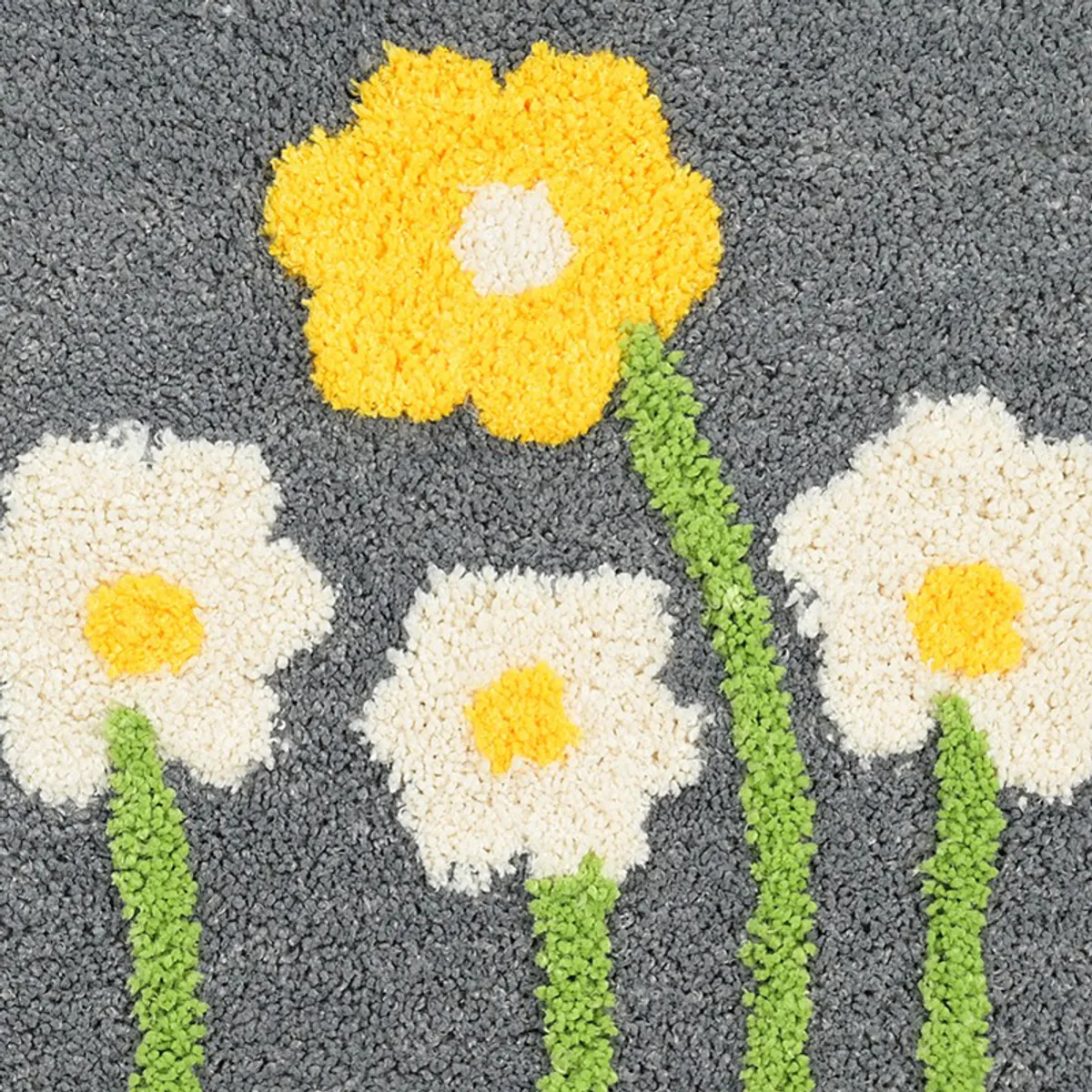 Close-up of yellow and white floral motif on textured grey bath mat