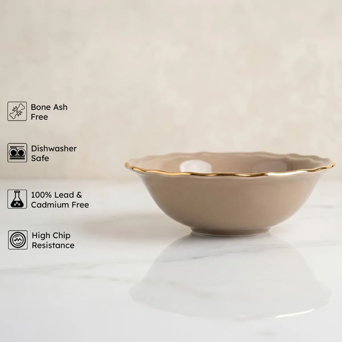 Grey serving bowl with gold rim shown on a marble surface