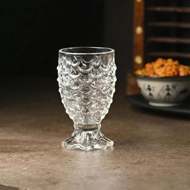 Clear cocktail glass with a scalloped embossed body and pedestal base