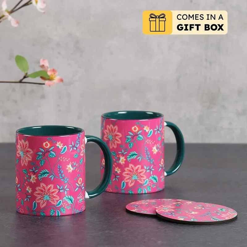 Two pink floral ceramic mugs with teal interiors and matching round coasters
