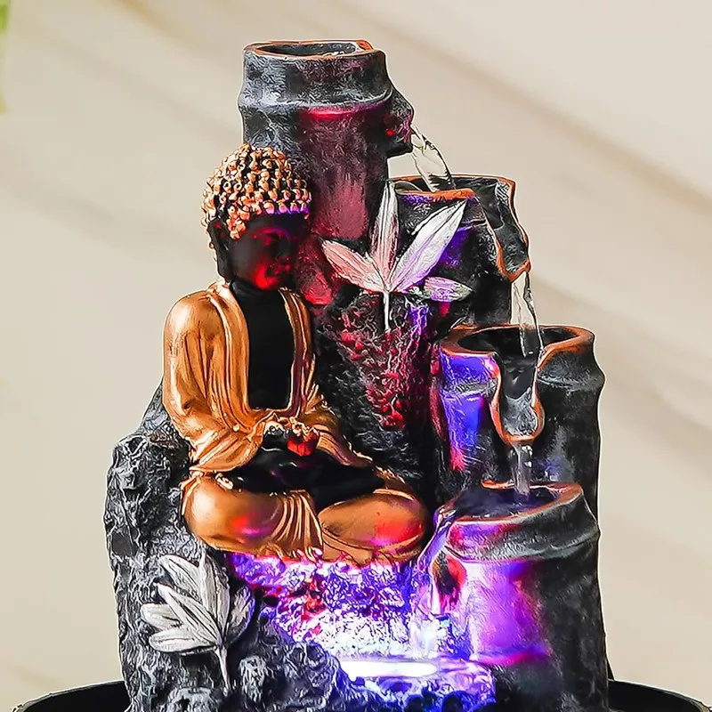 Close-up of Buddha figure and cascading fountain tiers with purple LED light