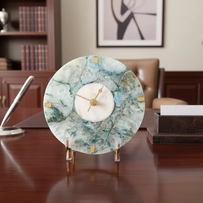 Round agate table clock with stand placed on a wooden office desk