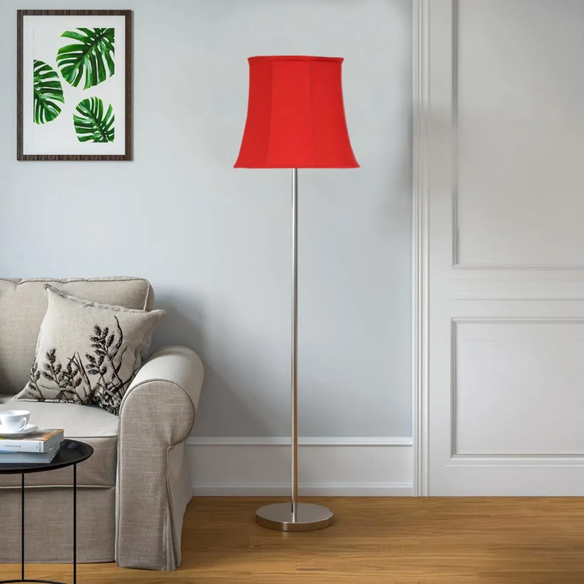 Red floor lamp with silver base in a bright room beside a beige sofa