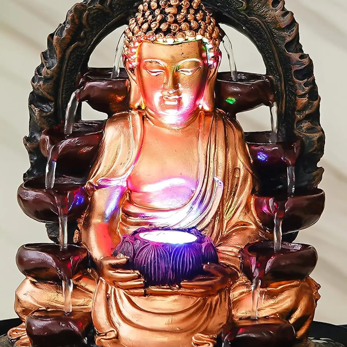 Close-up front view of the Buddha figure with illuminated bowl and water flow